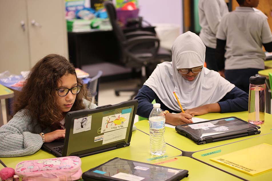 student in classroom smiling at camera